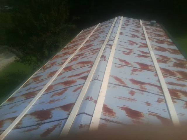 Rusted metal roof panels with new wood purlins before replacement — Storm Damage Roof Repair in Branford by Roofing Brothers
