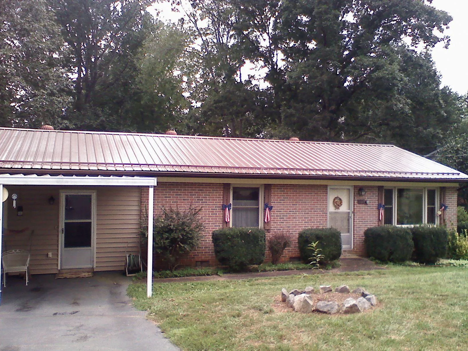 Bronze metal roof and carport on a brick ranch home — Roof Repair work by our crew in Branford